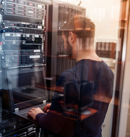 young it engeneer business man with thin modern aluminium laptop in network server room